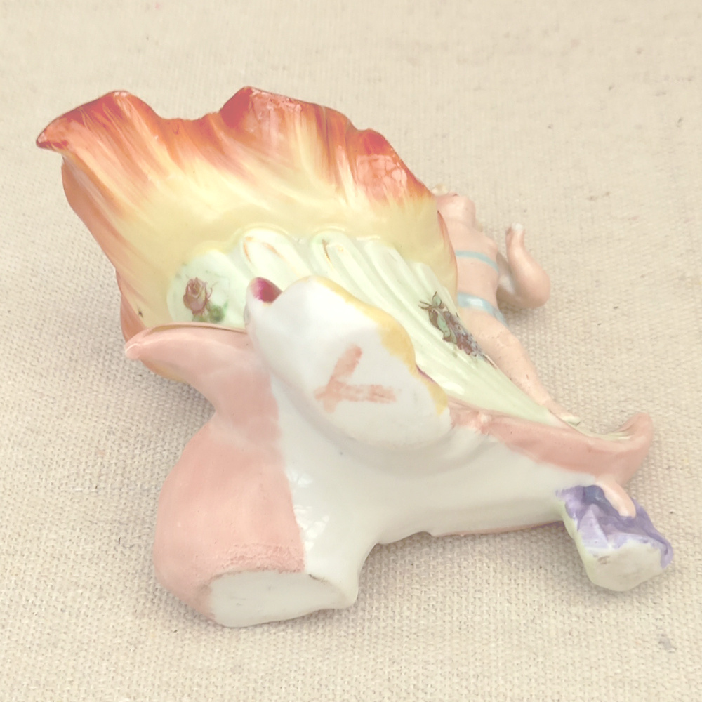 antique shaving mug with cupid holding soap illustration on ceramic surface