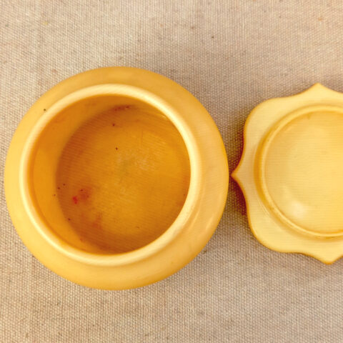 Vintage butterscotch phenolic lidded box with fine grain pattern, scalloped lid and Made in England mark on base