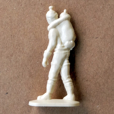Vintage margarine figurine of an Inuit woman carrying a baby on her back in traditional attire