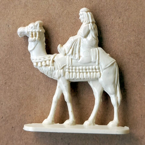 Vintage 1950s margarine figurine of Bedouin riding a camel with molded detail in traditional desert attire