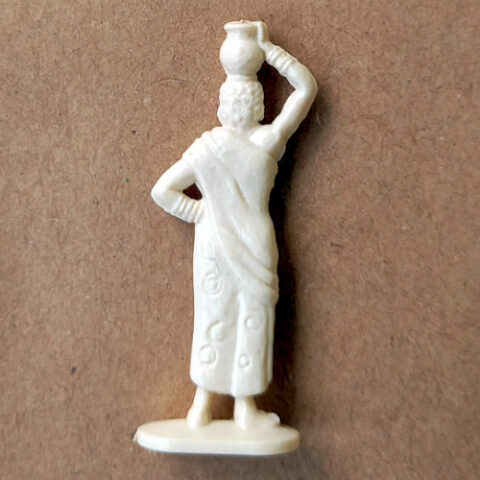 Vintage margarine figurine of a woman balancing a pot on her head in traditional attire