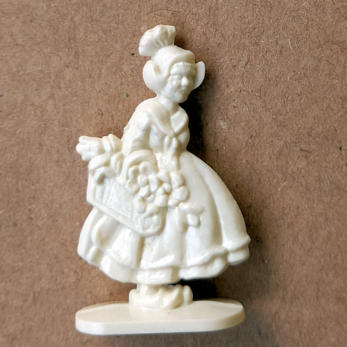 Vintage margarine figurine of a traditional Dutch woman wearing classic attire and bonnet