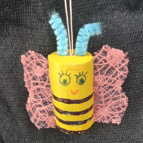 Bee made out of cork craft figure with painted black and yellow stripes and small wings