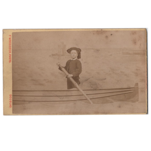 Victorian novelty studio photograph by F. Woodcock at Douglas Head, Isle of Man, showing a man posing behind a painted fake boat illusion.