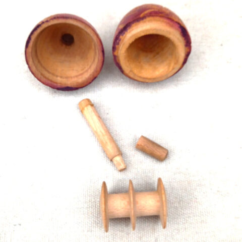 Antique carved wooden darning egg opening to reveal wooden thread spool and needle holder inside