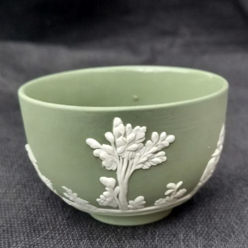 Vintage Wedgwood green jasperware bowl featuring classical relief scenes with figures, horses and trees, made in England circa 1960s.