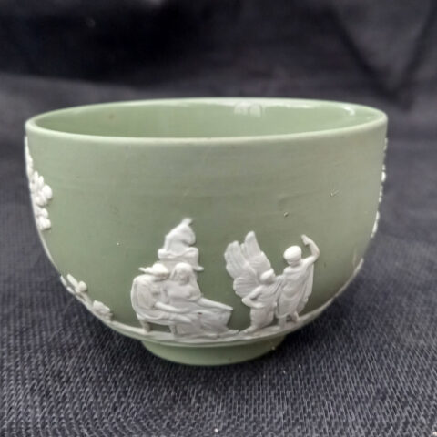 Vintage Wedgwood green jasperware bowl featuring classical relief scenes with figures, horses and trees, made in England circa 1960s.