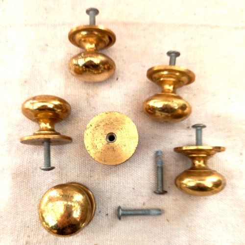Heavy-duty brass-coated classic round drawer knob fitted to a wooden cabinet drawer.