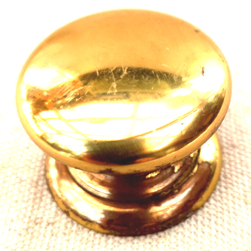 Heavy-duty brass-coated classic round drawer knob fitted to a wooden cabinet drawer.