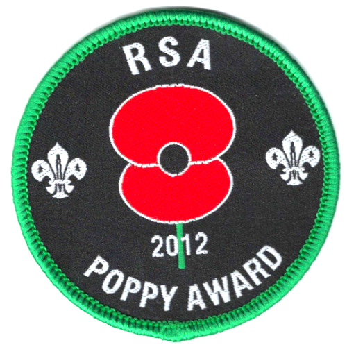 RNZRSA RSA 2012 Poppy Award embroidered badge with red poppy, Scout fleur-de-lis symbols, black background and green border.