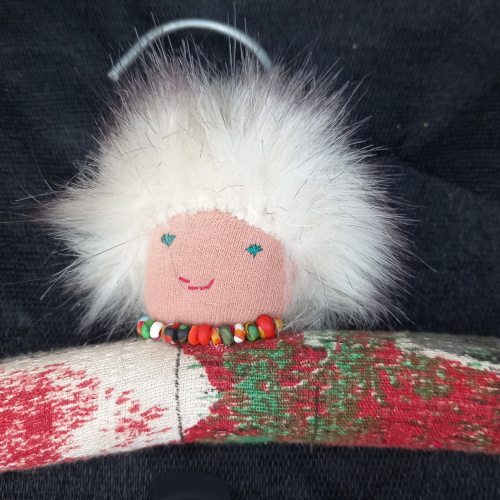 Old wooden clothes hanger transformed into a fun hanger with a sewn face and arms