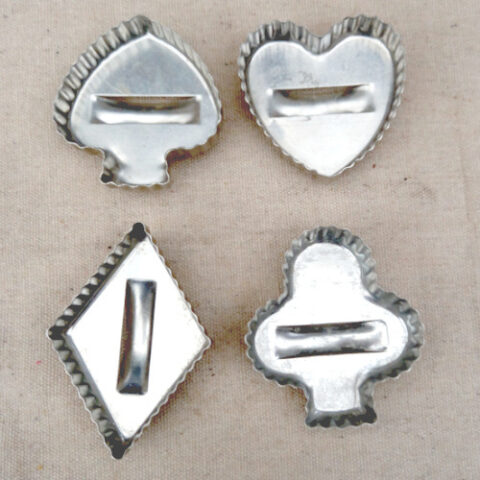 Four vintage aluminium cookie cutters with handles in spades, hearts, diamonds and clubs shapes