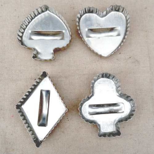 Four vintage aluminium cookie cutters with handles in spades, hearts, diamonds and clubs shapes