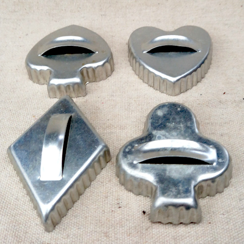 Four vintage aluminium cookie cutters with handles in spades, hearts, diamonds and clubs shapes