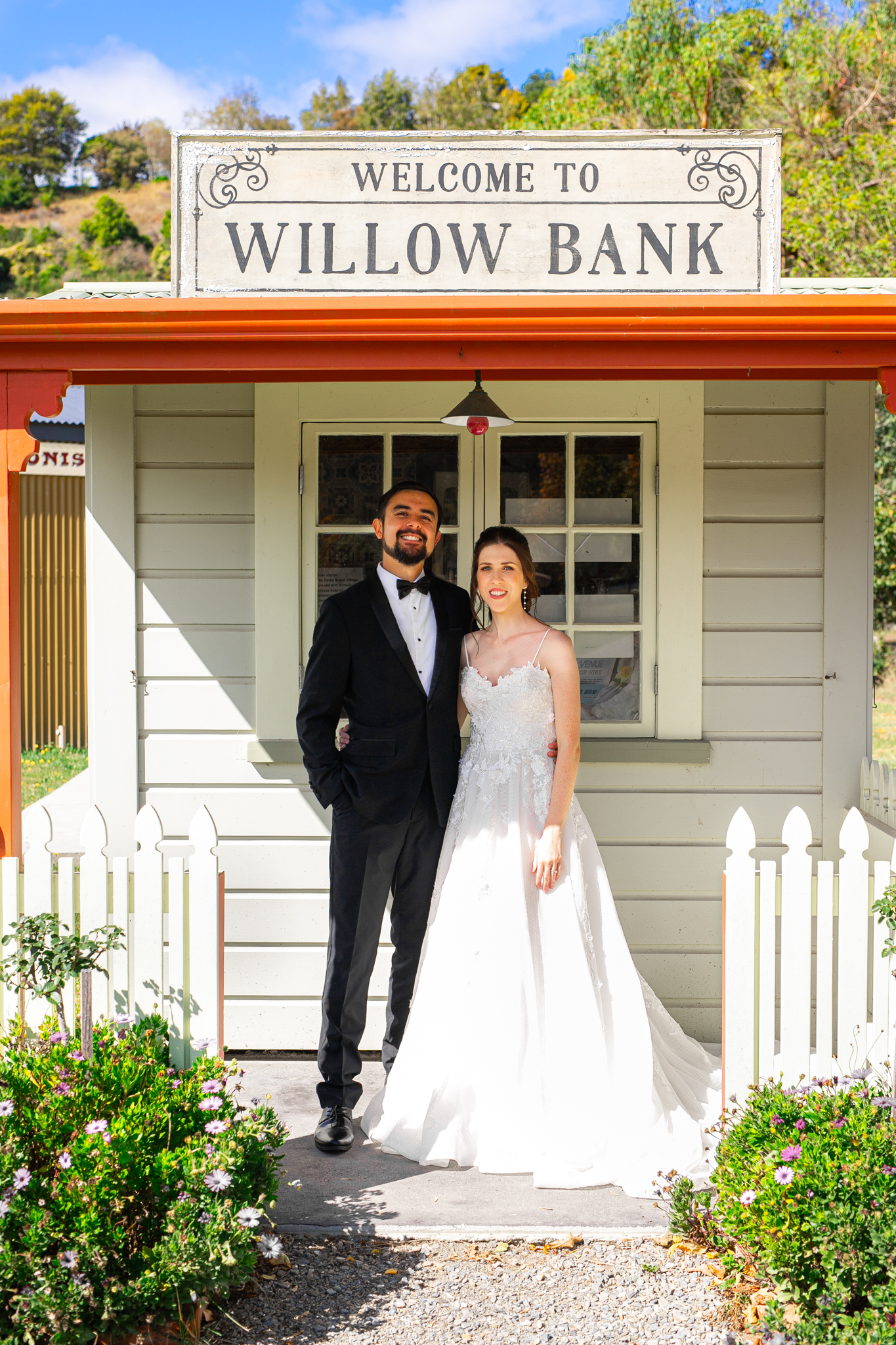 Bride and groom standing at the entrance building of Willow Bank Heritage Village wedding venue in Nelson