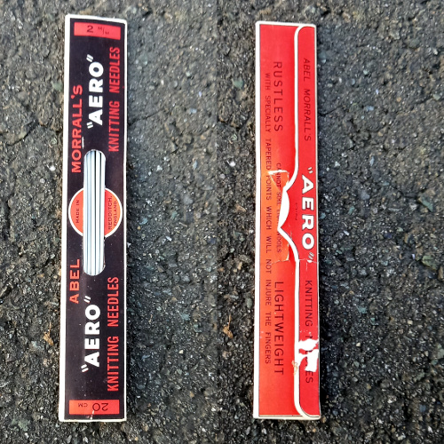 Vintage 2mm aluminium knitting needle in its original packet with a tear visible on the back of the packaging.
