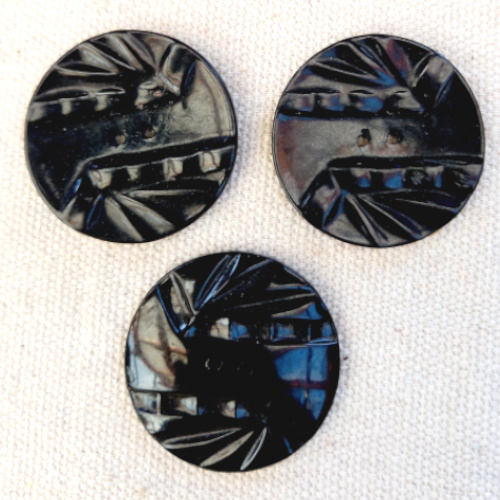 Three 34mm black embossed buttons from the 1950s