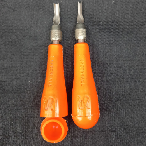 Two Speedball lino cutter handles with blades and storage compartments