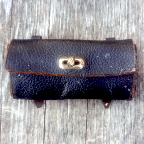 Vintage black leather bicycle tool bag mounted on a bicycle
