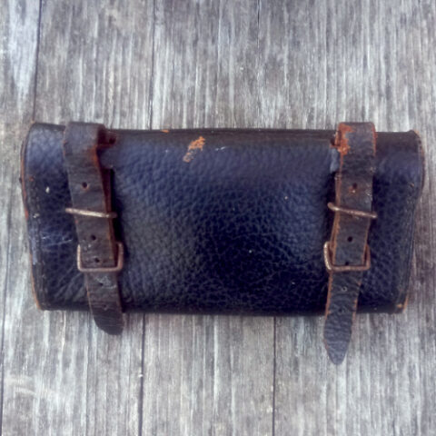Vintage black leather bicycle tool bag mounted on a bicycle