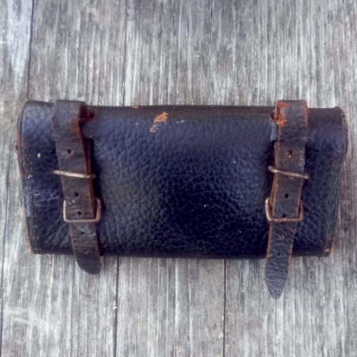 Vintage black leather bicycle tool bag mounted on a bicycle