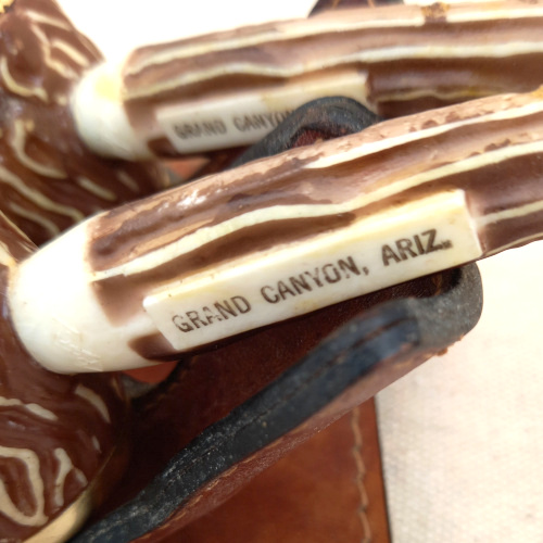 Vintage Grand Canyon Arizona salt and pepper shakers shaped like smoking pipes on a genuine leather stand