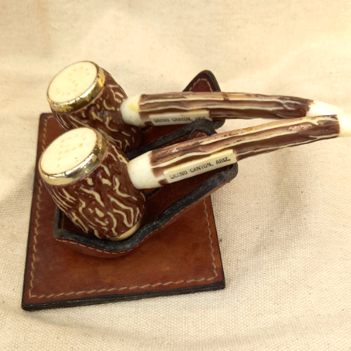 Vintage Grand Canyon Arizona salt and pepper shakers shaped like smoking pipes on a genuine leather stand