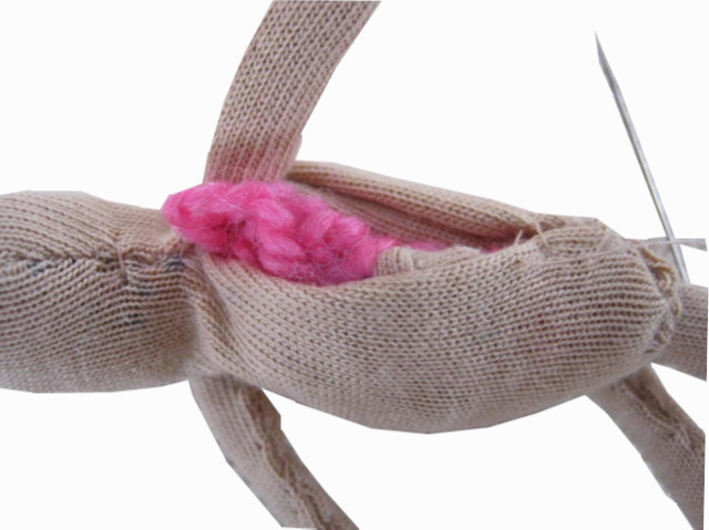 Handmade fabric doll with a stuffed head and body, pipe cleaner arms and legs, and fabric clothes