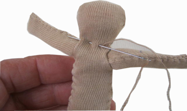 Handmade fabric doll with a stuffed head and body, pipe cleaner arms and legs, and fabric clothes