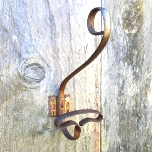 Antique wrought iron wall hook with curled scroll design and aged metal finish