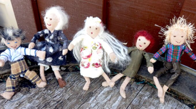 Handmade fabric doll with a stuffed head and body, pipe cleaner arms and legs, and fabric clothes