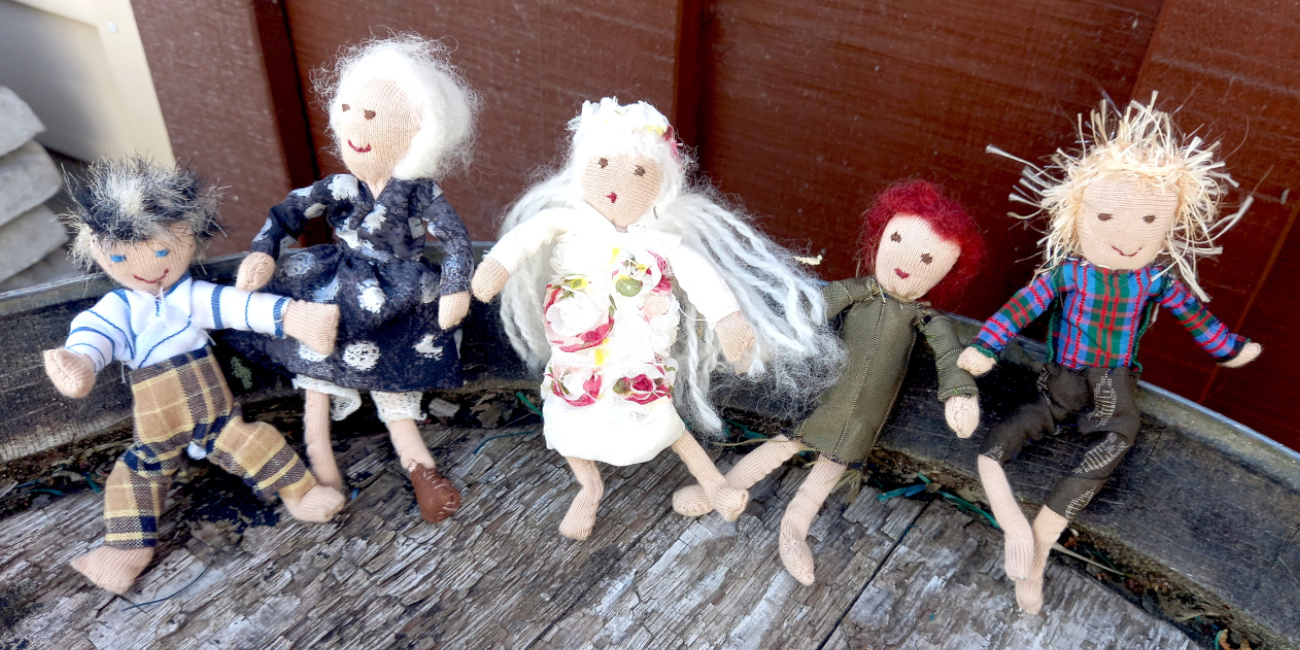 Handmade fabric doll with a stuffed head and body, pipe cleaner arms and legs, and fabric clothes