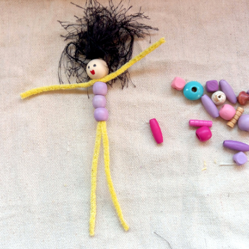 Handmade pipe cleaner person with a beaded body, wool hair and a painted bead face