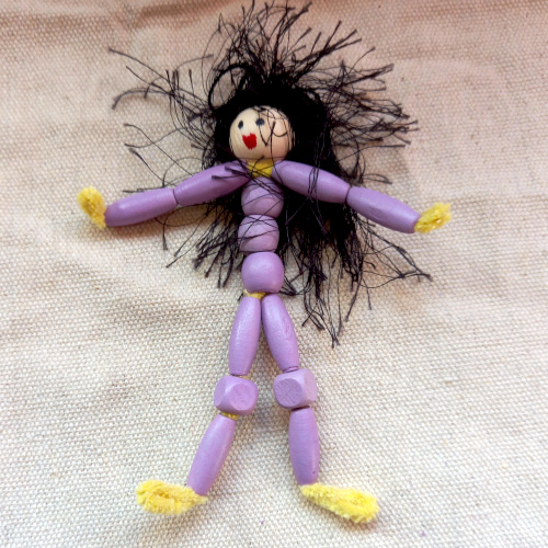 Handmade pipe cleaner person with a beaded body, wool hair and a painted bead face