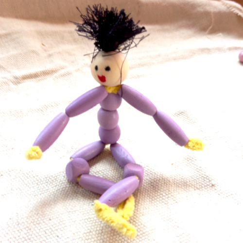 Handmade pipe cleaner person with a beaded body, wool hair and a painted bead face