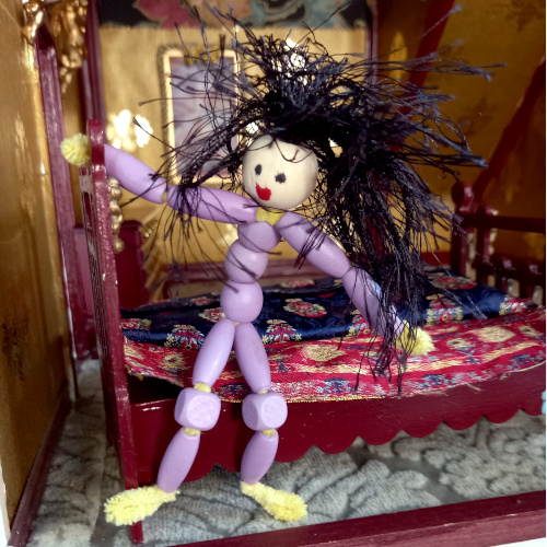 Handmade pipe cleaner person with a beaded body, wool hair and a painted bead face