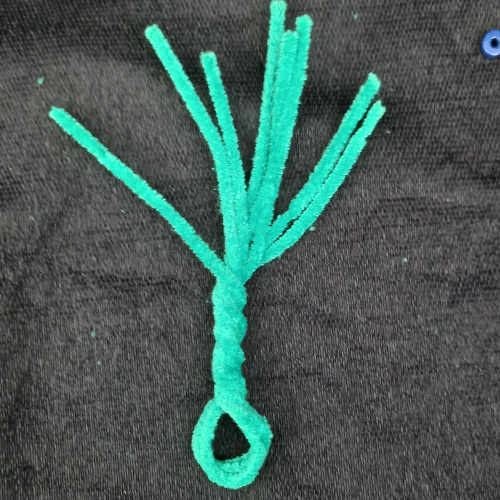 Handmade pipe cleaner tree decorated with wooden beads, with twisted branches and a base that stands upright.